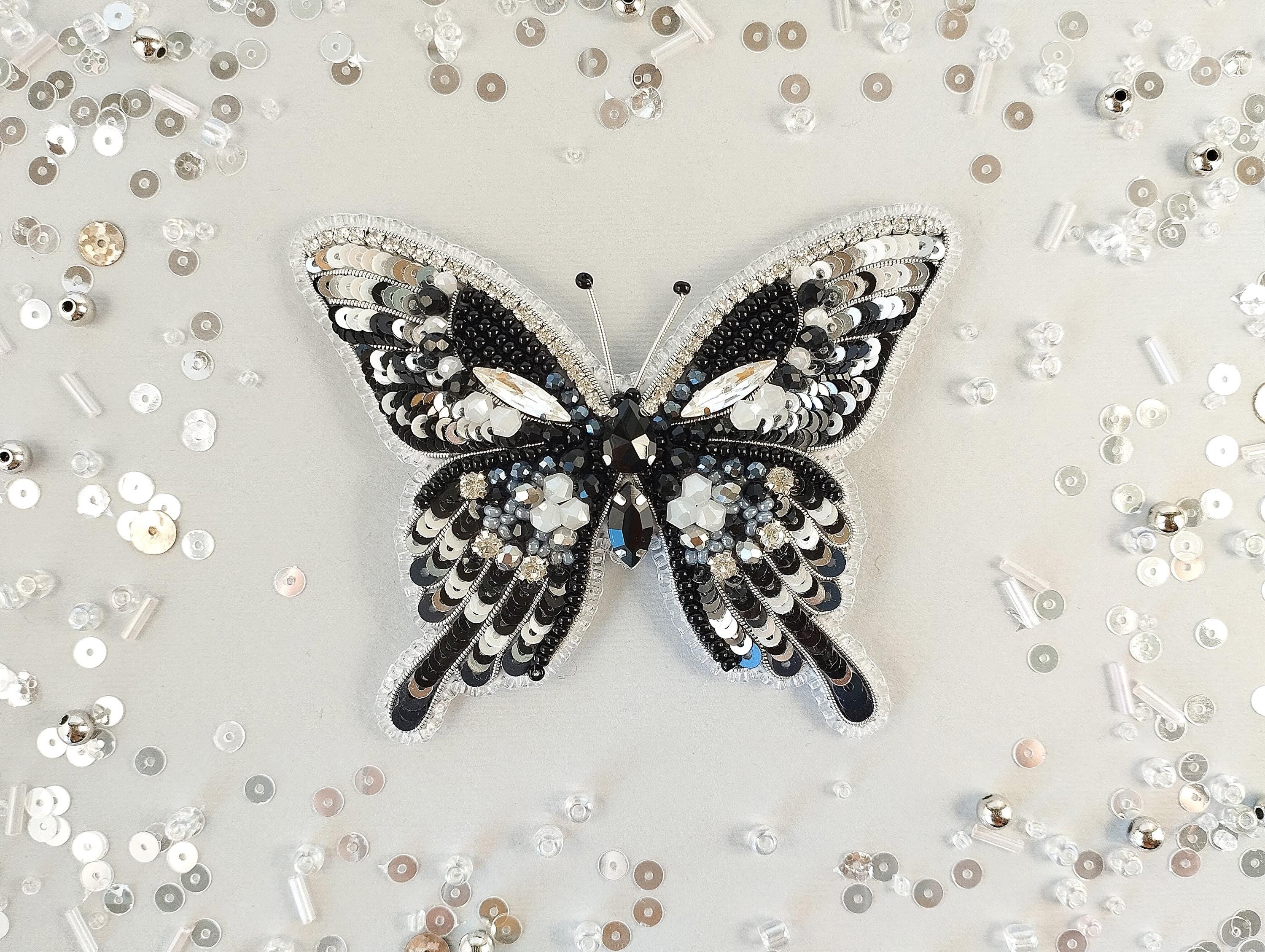 a black and white butterfly brooch sitting on top of a table
